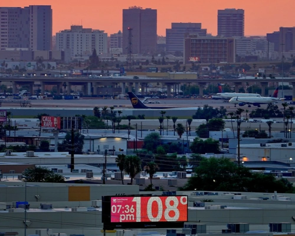 لافتة تُظهر درجة حرارة 108 فهرنهايت أثناء سير الطائرات.