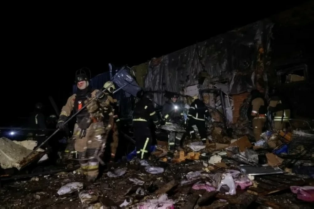 رجال إطفاء يعملون في موقع غارة روسية بمنطقة خاركيف الأوكرانية