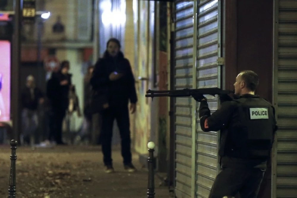 ضابط شرطة فرنسي أثناء بحثه عن مطلقي النار في مطعم في باريس خلال الهجمات الإرهابية 2015 (إ ب أ)