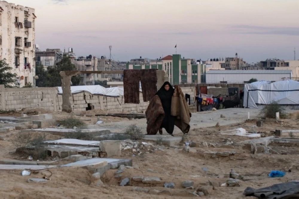 فلسطينية نازحة لجأت إلى العيش في المقابر وسط ظروف إنسانية قاسية.(إ ب أ)