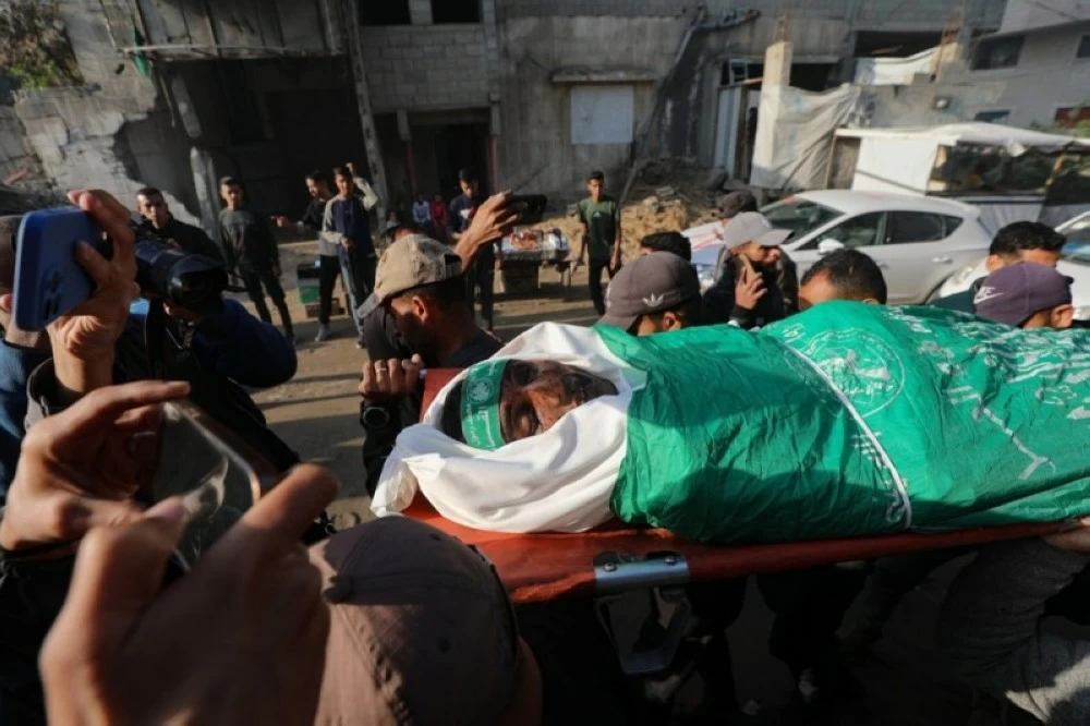 فلسطينيون يحملون جثمان فلسطيني قُتل في غارات جوية إسرائيلية، في مستشفى الشفاء بمدينة غزة.(ة إ ب أ)