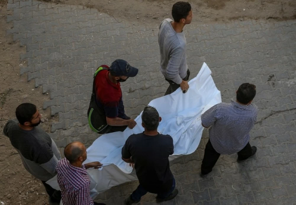 فلسطينيون يحملون جثمان أحد أفراد عائلة الخضري الذي قتلته إسرائيل في غزة. (إ ب أ)