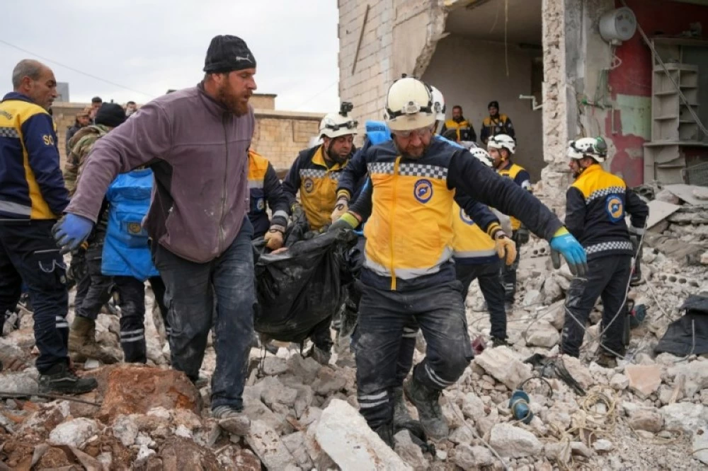 الدفاع المدني السوري يحمل جثة قتيل في انفجار مخلفات حرب في بلدة النيرب بريف إدلب .(إ ب ا)