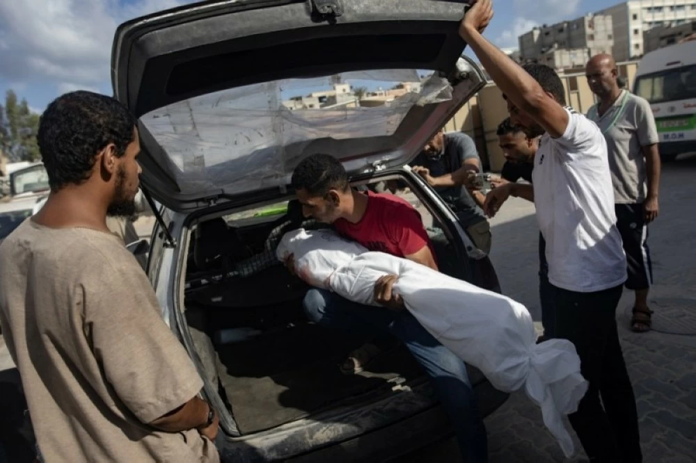 فلسطينيون يحملون جثث أشخاص قُتلوا في غارات إسرائيلية على مخيم خان يونس جنوب قطاع غزة. 
(إ ب أ)