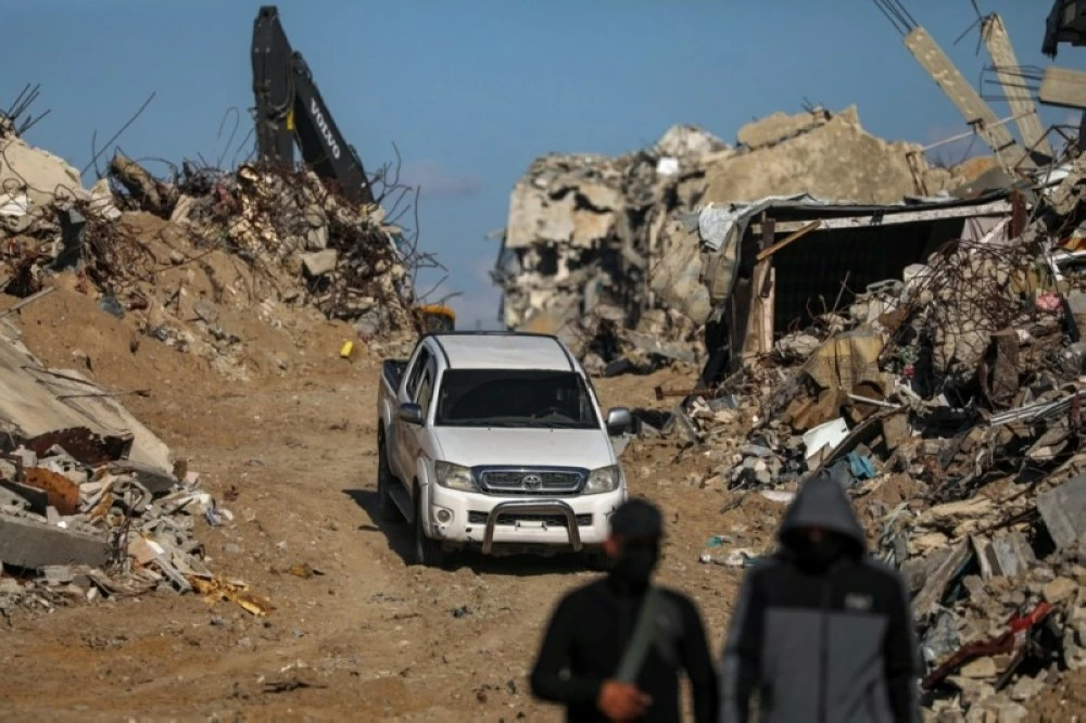 مقاتلون من حركة حماس يقفون للحراسة أثناء البحث المستمر عن جثث الرهائن الإسرائيليين. (إ ب أ)