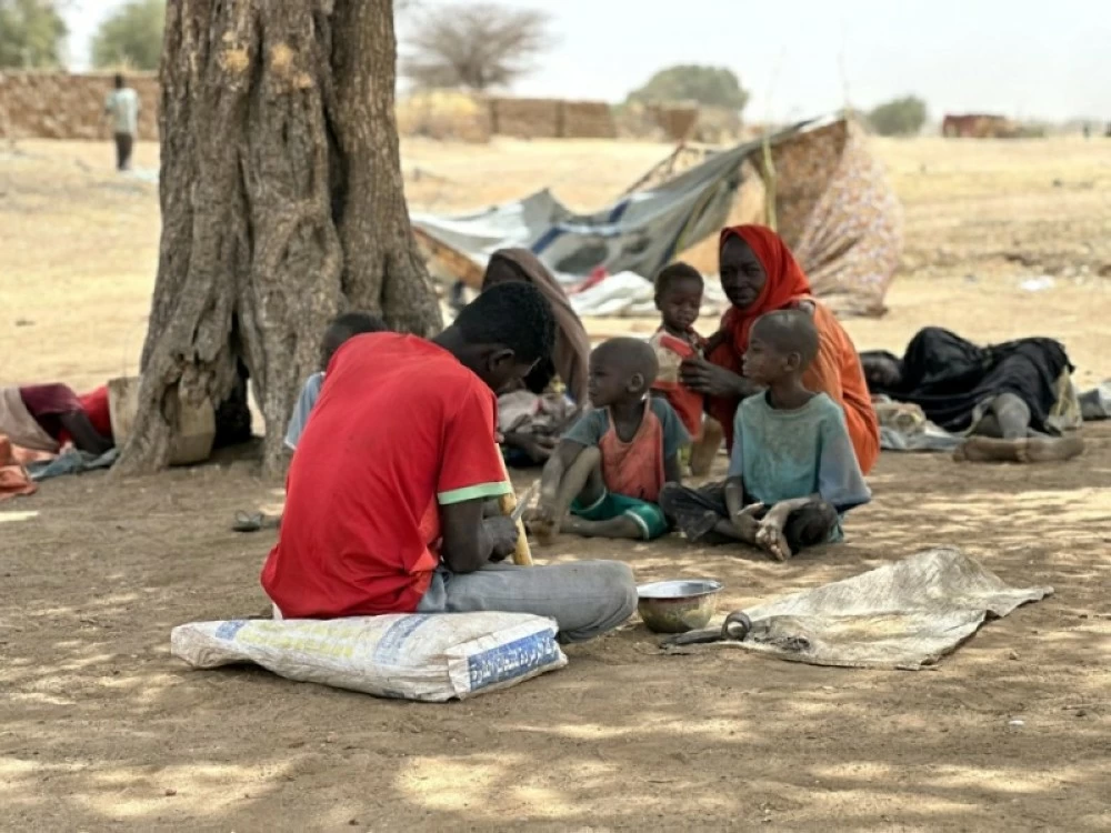 سودانيون فروا من مخيم زمزم للنازحين يستريحون أثناء توجههم إلى مخيمات طويلة. ( إ ب أ) 