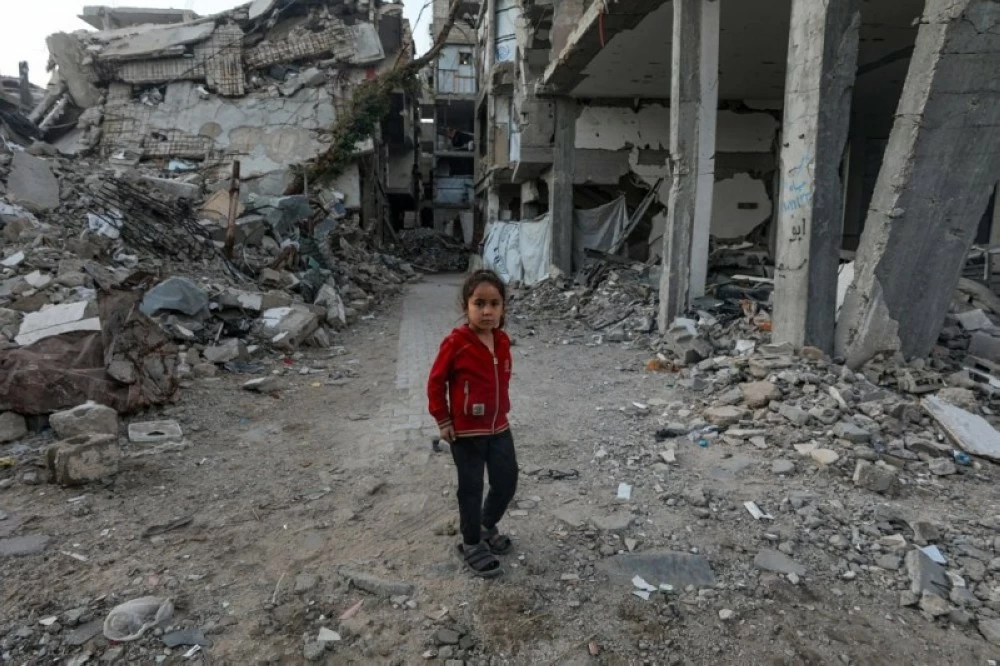 فتاة فلسطينية تقف بجوار أنقاض منزل عائلتها  المدمر في مدينة غزة (إ ب أ)