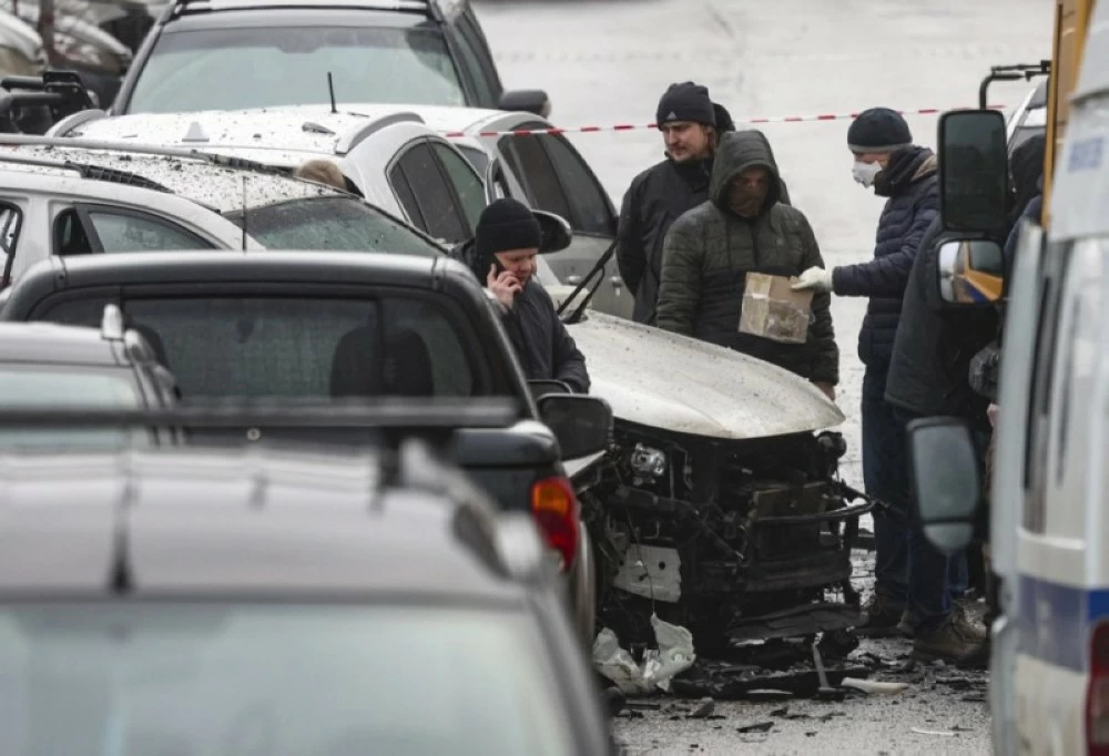  محققون روس قرب سيارة الجنرال فانيل سارفاروف  بعد انفجار عبوة ناسفة زُرعت أسفلها في منطقة سكنية بالعاصمة. ( إ ب أ) 