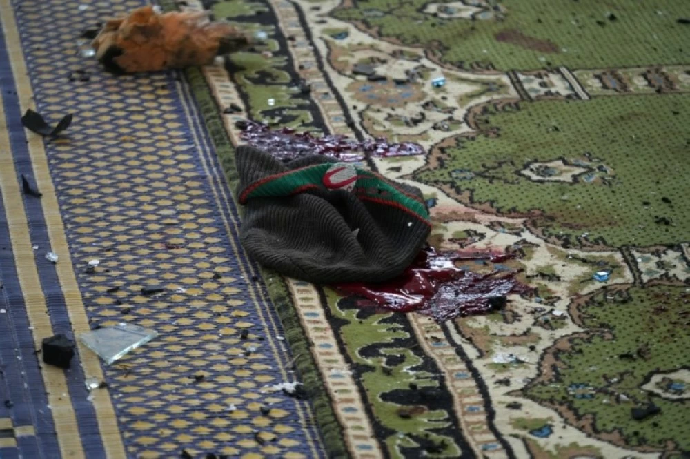 دماء على أرضية المسجد الذي استهدفه التفجير الإرهابي في حمص.(إ ب أ)