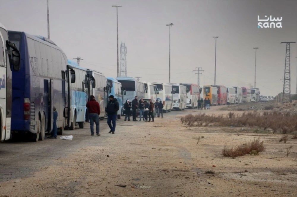  حافلات قرب من دوار الليرمون بحلب  لنقل عناصر تنظيم قسد إلى شمال شرق البلاد.