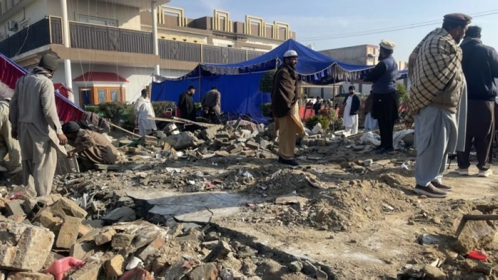 عمال الإنقاذ يتفقدون موقع الهجوم الانتحاري في دير إسماعيل خان. (إ ب أ) 