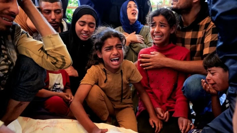 فلسطينيات يبكين خلال تشييع ضحايا الحرب .