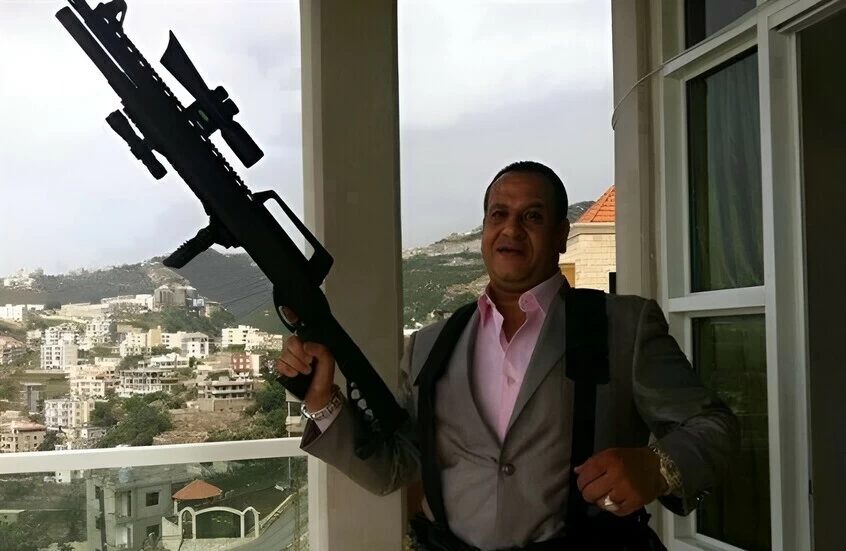 صبري نخنوخ مستعرضاً سلاحاً نارياً.