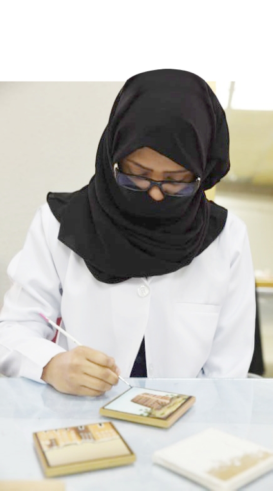 فتاة تعمل في ورشة صناعة الهدايا التذكارية بواسطة السيراميك في الجمعية الفيصلية الخيرية في جدة. (تصوير: أمل السريحي)