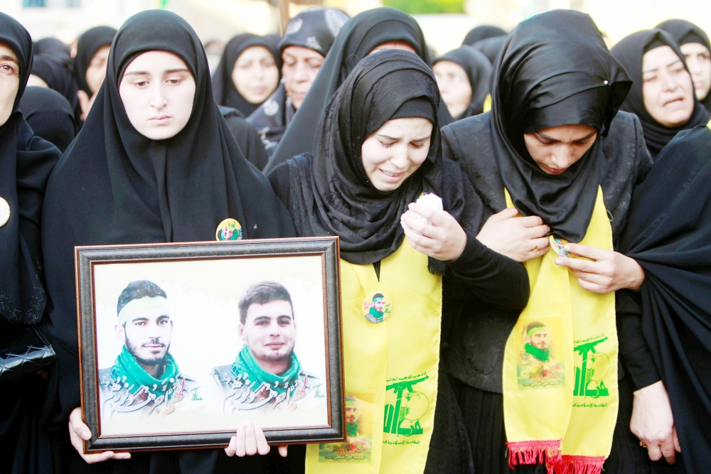 The sister (C) of Hezbollah fighter Mohamad al-Shami, who was killed during clashes in Syria's Aleppo, morns during his funeral in Bisariye village, southern Lebanon October 24, 2016. REUTERS/Ali Hashisho