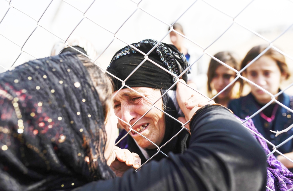 Newly displaced Iraq's who fled from the city of Mosul, Iraq's last major Islamic State (IS) group stronghold, meet their relatives who came two years ago to the refugee camp in the Khazer area, near near the Kurdish checkpoint of Aksi Kalak, some 40 kilometres east of Arbil following their arrival on October 26, 2016.  The United Nations Office for the Coordination of Humanitarian Affairs (OCHA) Stephane Dujarric told reporters that almost 9,000 people are internally displaced as a result of the Mosul military operation in Iraq. Lise Grande, the U.N. humanitarian coordinator for Iraq, said the military operations to retake Mosul could spark the largest humanitarian crisis in 2016 as the security situation in the area restrains aid agencies' ability to deliver help. / AFP / BULENT KILIC
