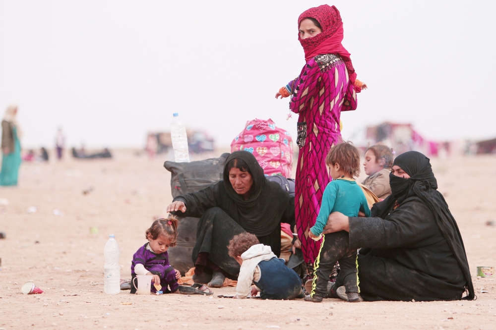 لاجئات عراقيات هربن من جحيم المواجهات في الموصل إلى الحدود السورية قرب الحسكة أمس. (رويترز)