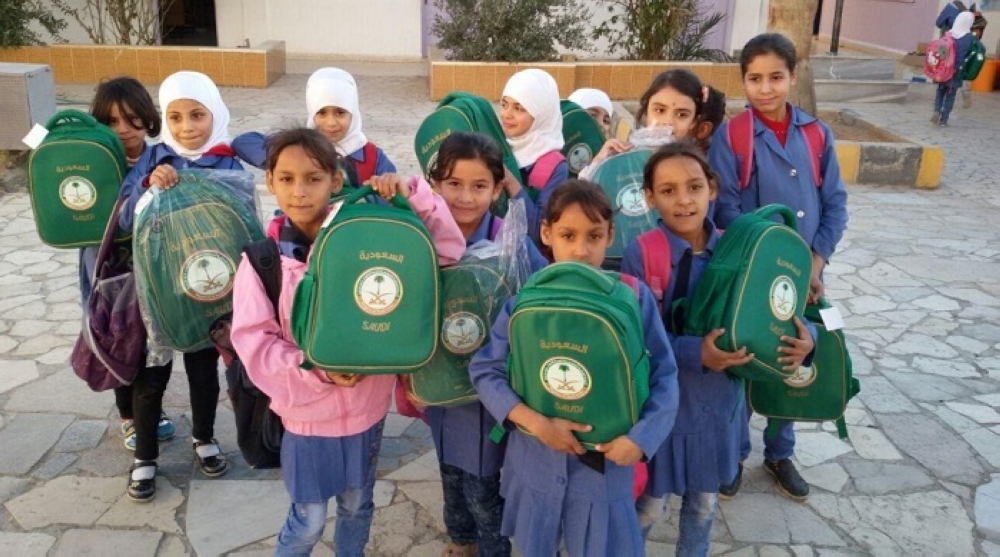 طالبات سوريات في الرمثا الأردنية يحملن الحقائب المدرسية المقدمة لهن من الحملة السعودية