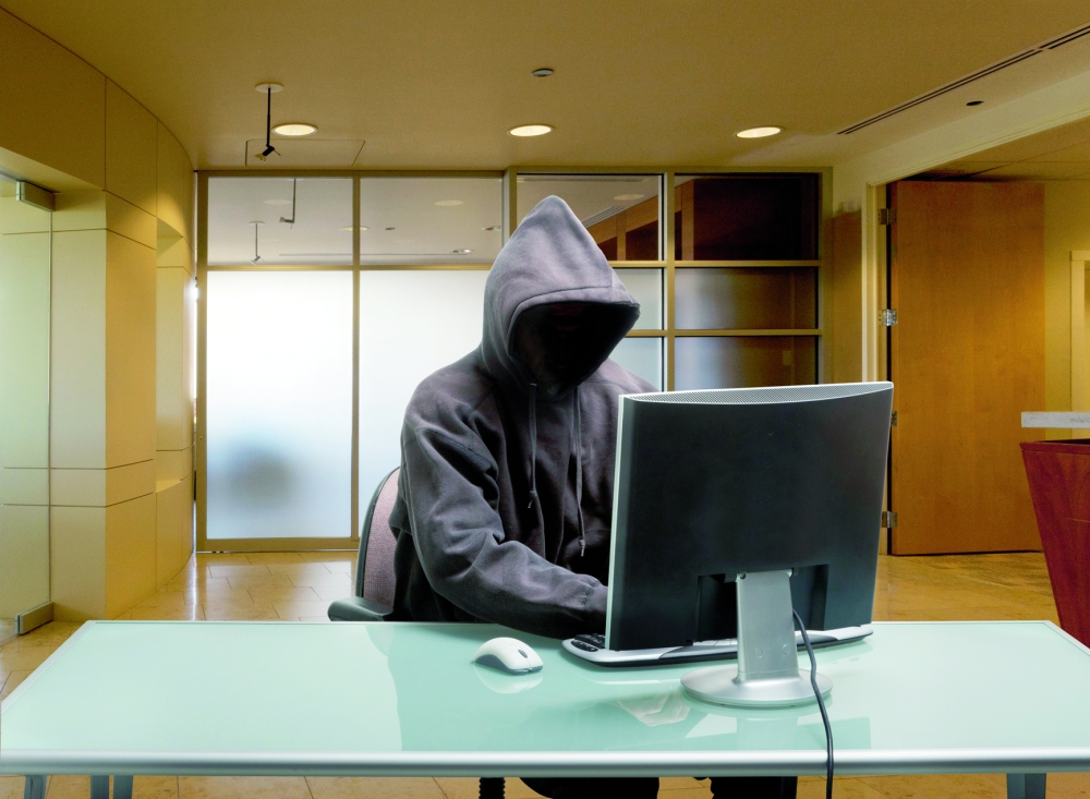 Caucasian man in hoody sitting at office desk