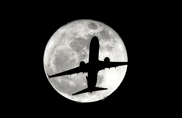 A passenger plane heading to Los Angeles International Airport passes by the supermoon Monday, Nov. 14, 2016. The phenomenon known as the supermoon occurs because the moon follows an elliptical orbit around the Earth. This week, the moon is coming closer to the Earth than at any time since January 1948. (AP Photo/Nick Ut)