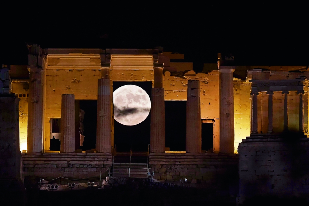 TOPSHOT - The 'Supermoon' rises behind the Propylaea above the Ancient Acropolis hill in Athens on November 14, 2016.  The moon will be the closest to Earth since 1948 at a distance of 356,509 kilometres (221,524 miles), creating what NASA described as 