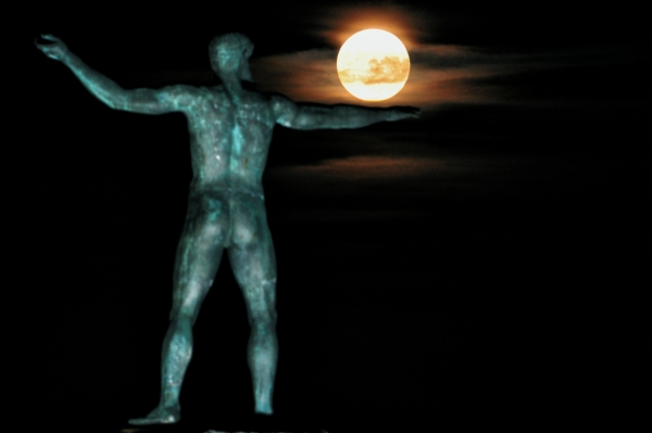TOPSHOT - The 'Supermoon' rises above the statue of the ancient  Greek god Poseidon in Ancient Corinth on November 14, 2016.  Skygazers headed to high-rise buildings, ancient forts and beaches on November 14 to witness the closest 