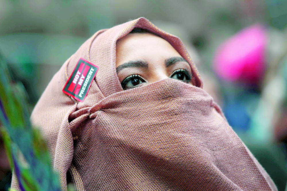 أمريكية مسلمة تشارك في مسيرة حاشدة ضد الرئيس الأمريكي في نيويورك أمس. 