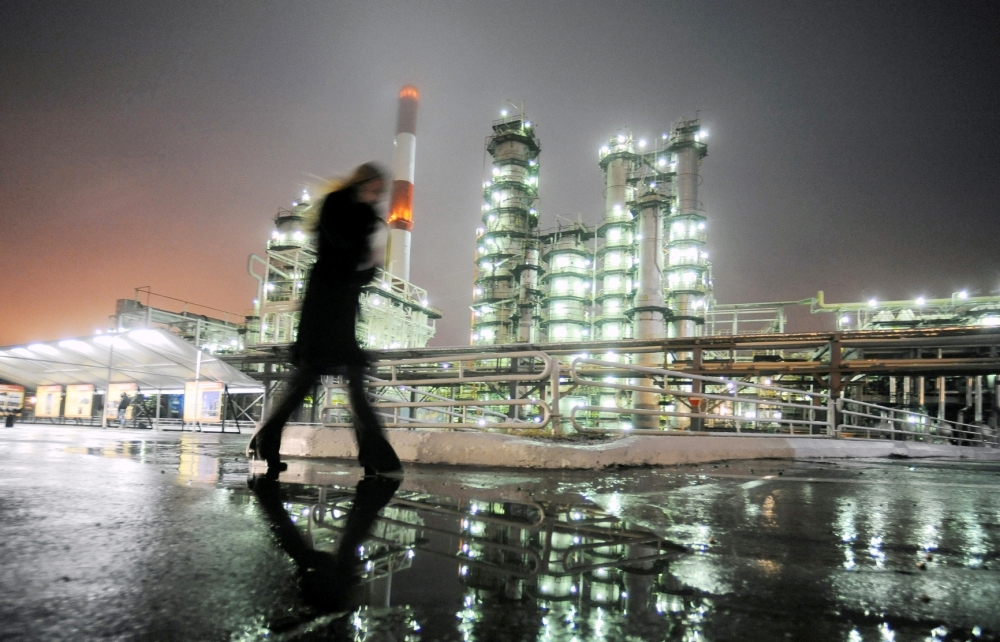 مواصلة خفض الإنتاج من قبل كبار الدول المنتجة يعزز سعر البرميل في أسواق النفط العالمية، وفي الصورة، امرأة تسير أمام مصفاة نوفوكويبيشفسك. (رويترز)