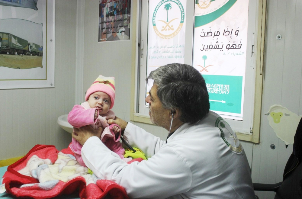 طبيب يكشف على طفلة سورية في العيادات.