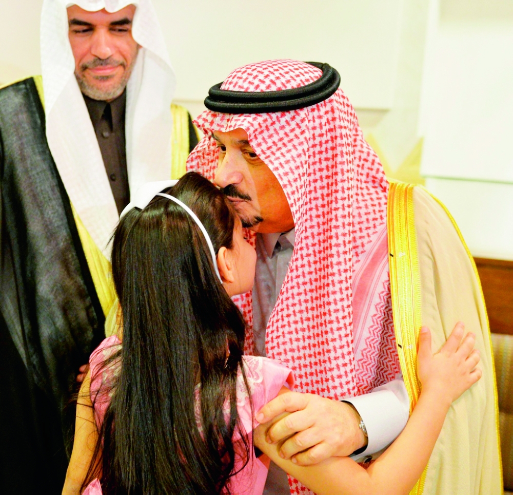 الأمير فيصل بن بندر يطبع قبلة على جبين طفلة. (واس)
