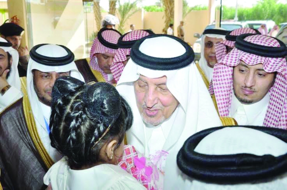 الأمير خالد الفيصل ملاطفاً طفلة خلال زيارة سابقة للليث.