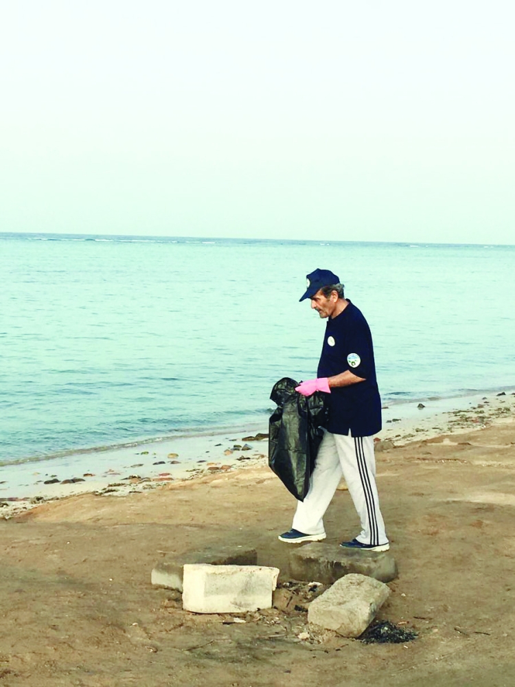 الفريق متقاعد عبدالعزيز هنيدي خلال تنظيف الشاطئ.
