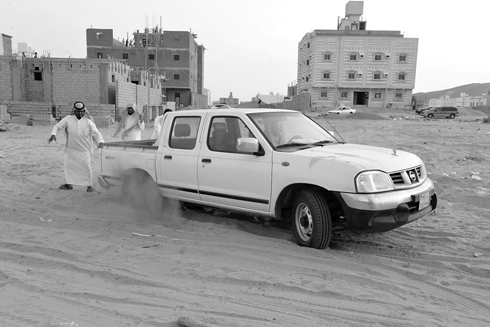 سيارة عالقة في الرمال في أحد الشوارع. (تصوير: عمران محمد)