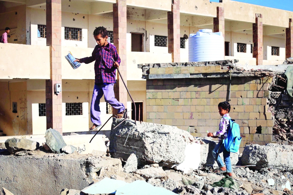 طفل يمني يقف على ركام مدرسته التي دمرتها ميليشيا الحوثي في تعز. (أ. ف. ب)