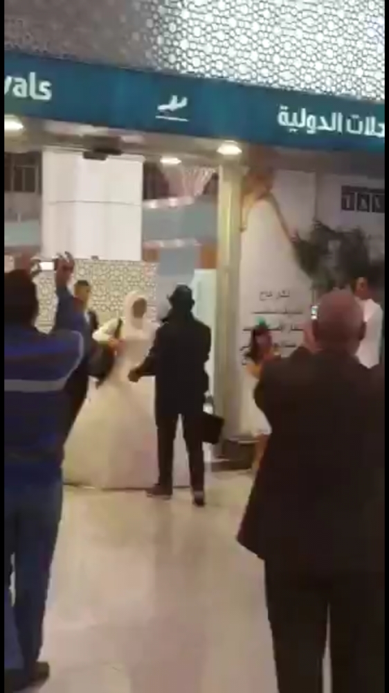 لحظة استقبال العريس لعروسه في مطار المدينة المنورة.
