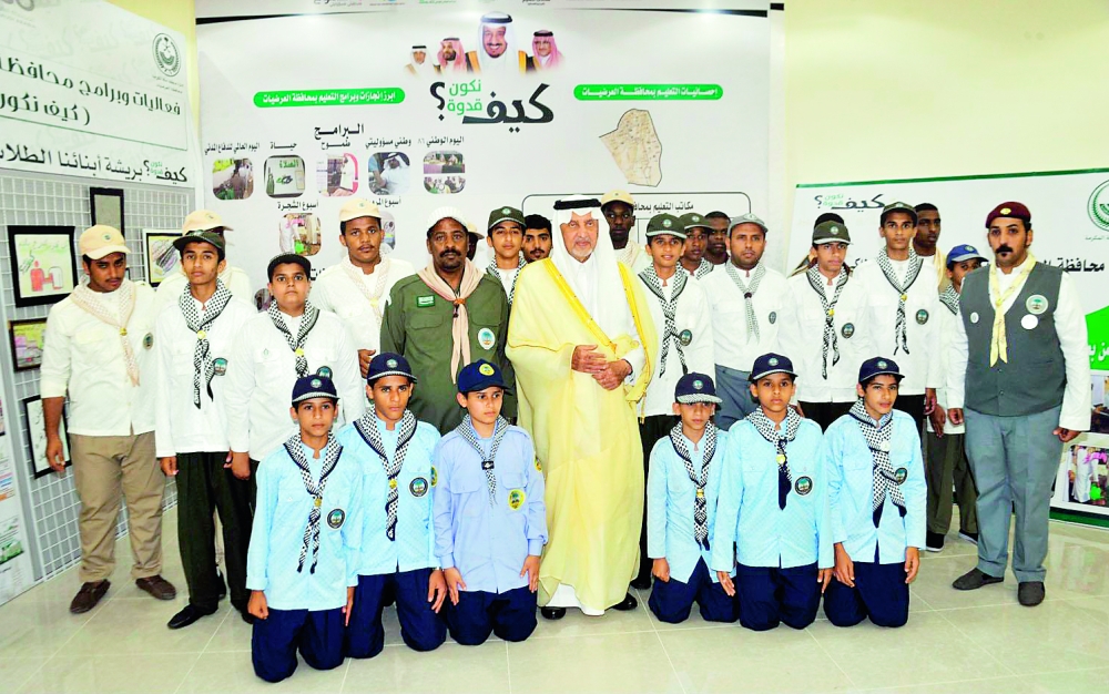 الأمير خالد الفيصل متوسطا عددا من أبناء العرضيات خلال زيارته أمس.   (عكاظ)