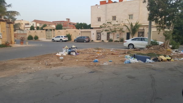 النفايات تنتشر في شوارع الحي. (عكاظ)