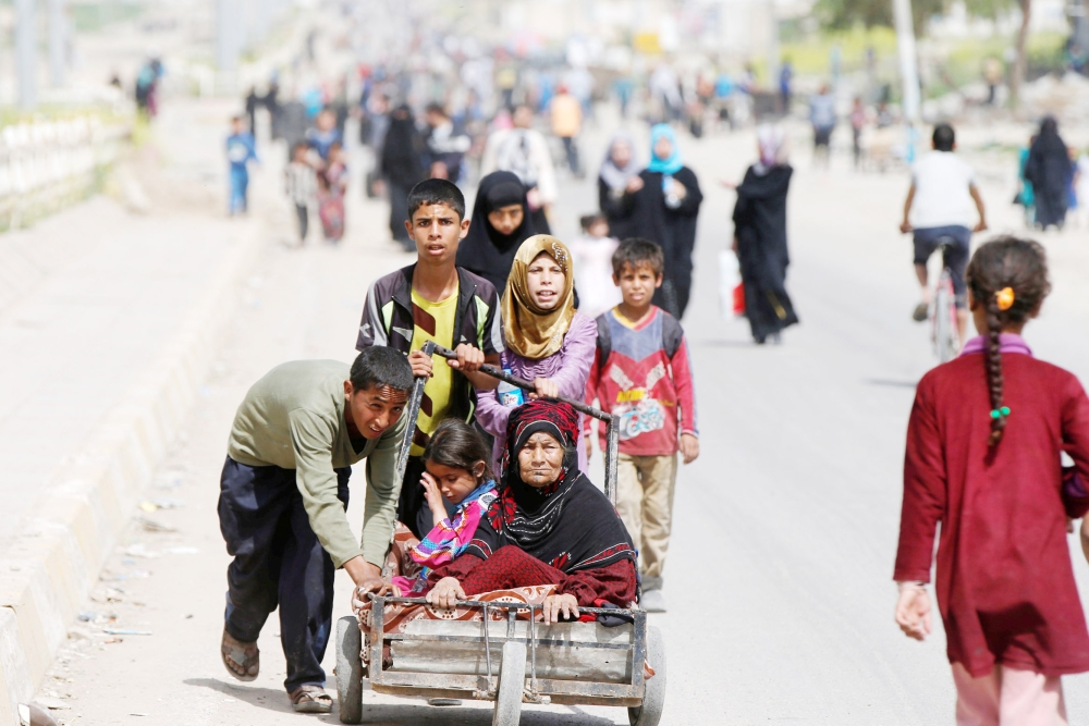 أسرة عراقية نازحة من الموصل بعد احتدام المواجهات مع «داعش» أمس. (أ. ف. ب)