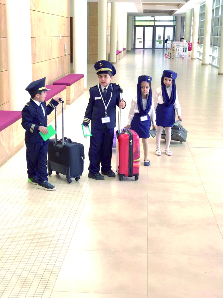 «كابتن الطائرة ومساعده» والمضيفات من الأطفال المشاركين. (عكاظ)