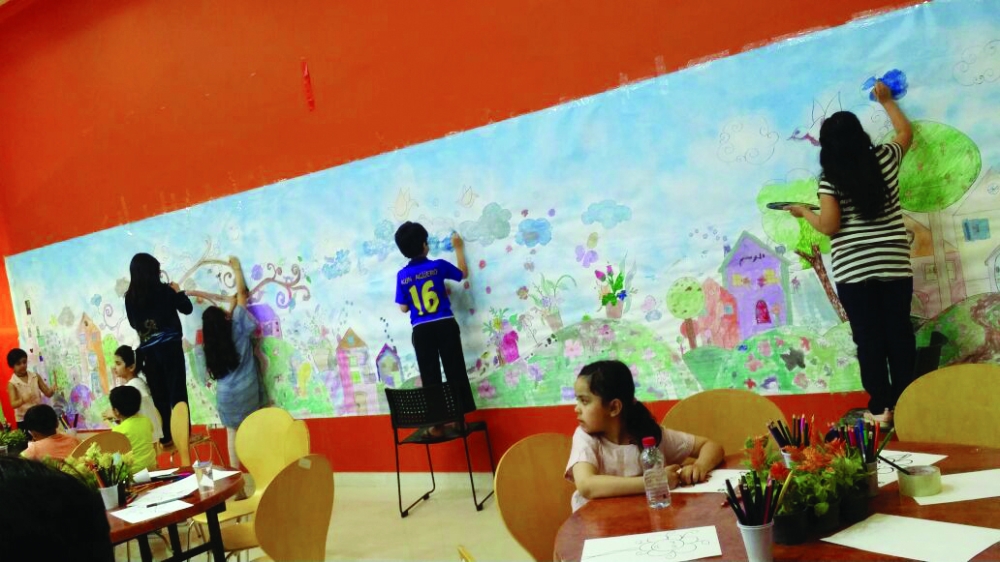 الأطفال يلونون الجدارية.
