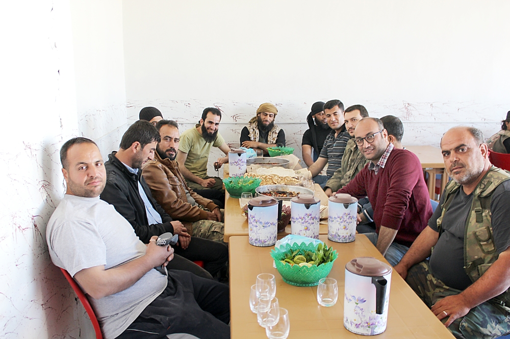 الزميل عبدالله الغضوي مع مجموعة من المقاتلين في دعوة على الغداء في جرابلس. (خاص)