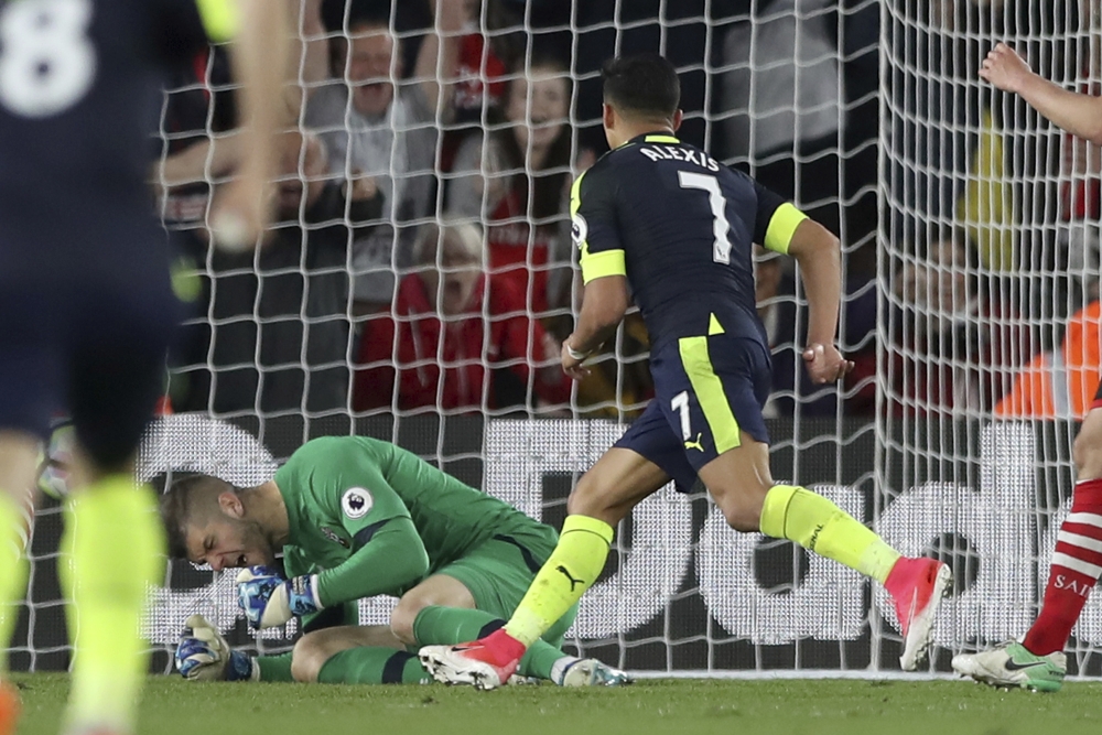 Arsenal's Alexis Sanchez, 7, celebrates scoring his side's first goal as Southampton's goalkeeper Fraser Forster reacts during the English Premier League soccer match between Southampton and Arsenal at St Mary's stadium in Southampton, England, Wednesday, May 10, 2017. (AP Photo/Alastair Grant)