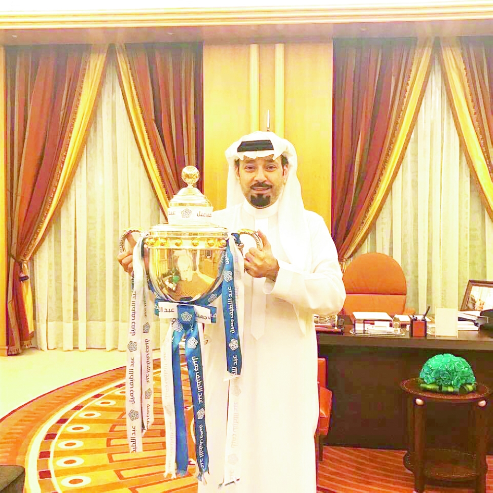 مشعل بن عبدالله يحمل كأس الدوري.