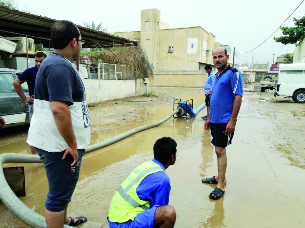 أعمال شفط مياه الأمطار من الشارع. (عكاظ)