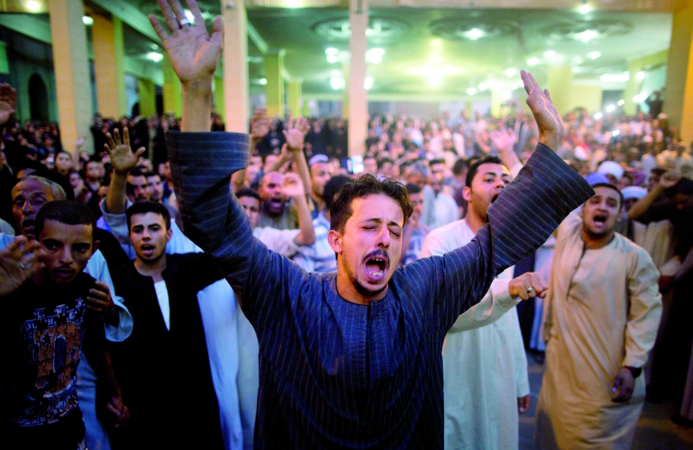 أقارب ضحايا مذبحة المنيا يصرخون أثناء تشييع عدد من الجثامين أمس. (أب، رويترز)