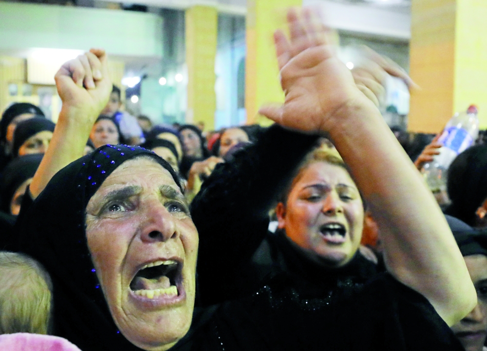 
 قريبات ضحايا الهجوم الإرهابي يبكين أثناء تشييع الجثامين في المنيا، أمس( رويترز )