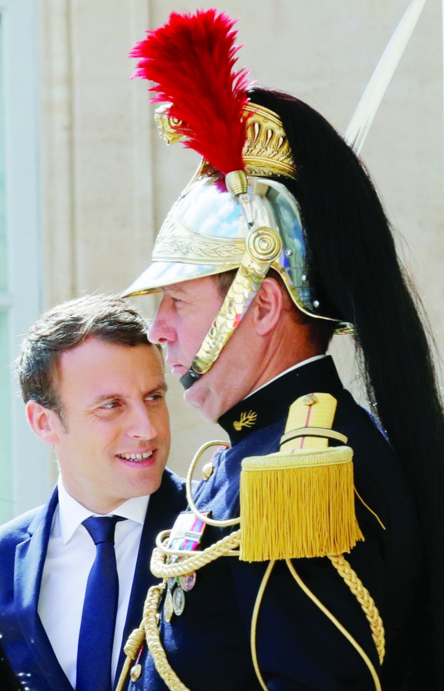 ماكرون ينتظر مغادرة ضيوف في قصر الإليزيه في باريس أمس. (رويترز)