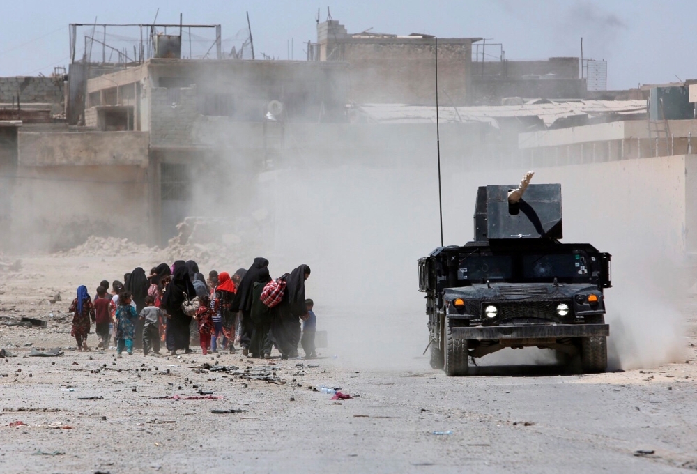 مدنيون أثناء فرارهم من مدينة الموصل القديمة (رويترز)
