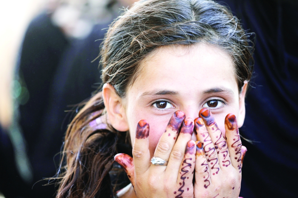 طفلة عراقية نازحة من الموصل تنتظر الحصول على مساعدات غذائية أمس الأول. (رويترز)