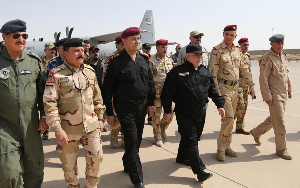 رئيس الوزراء العراقي حيدر العبادي  يسير جنبا إلى جنب مع ضباط الشرطة والجيش عند وصوله إلى الموصل. 